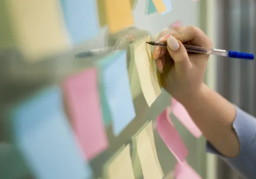 woman-writing-sticky-notes-office-window